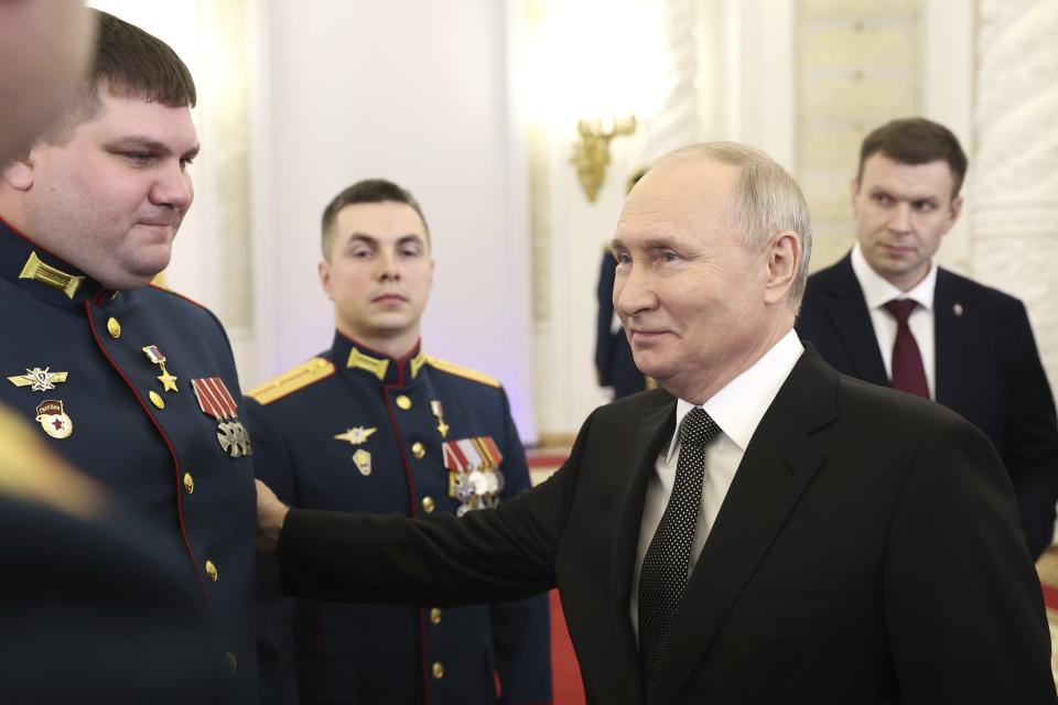 FILE - Russian President Vladimir Putin talks with servicemen after a ceremony to present Gold Star medals to Heroes of Russia on the eve of Heroes of the Fatherland Day at the St. George Hall of the Grand Kremlin Palace in Moscow, Russia, Friday, Dec. 8, 2023. With the fighting in Ukraine now entering its third year, Putin is biding his time and waiting for Western support for Ukraine to wither while Moscow maintains its steady military pressure along the front line. (Valery Sharifulin, Sputnik, Kremlin Pool Photo via AP, File)