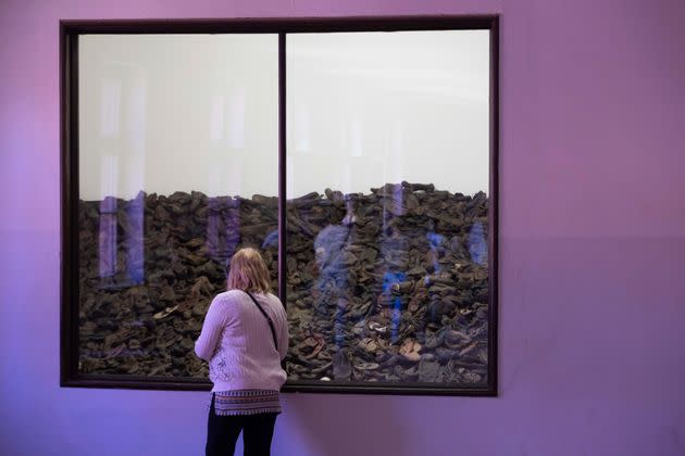 A woman looks at an exhibition displaying the shoes of child victims of the former Nazi German death camp Auschwitz-Birkenau.