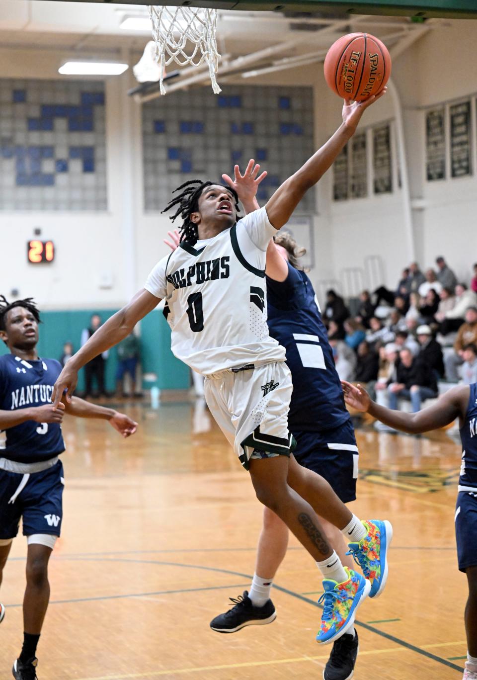 Shea Dwyer of Nantucket reaches across Elijah Searight of Dennis-Yarmouth as he goes to the hoop.