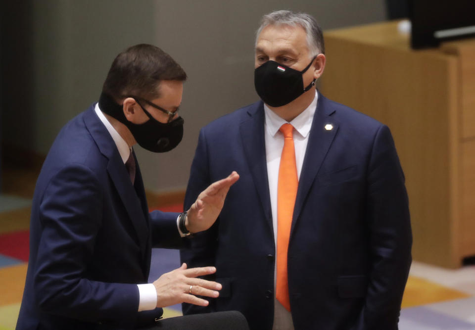 Poland's Prime Minister Mateusz Morawiecki, left, speaks with Hungary's Prime Minister Viktor Orban during a round table meeting at an EU summit at the European Council building in Brussels, Thursday, Dec. 10, 2020. European Union leaders meet for a year-end summit that will address anything from climate, sanctions against Turkey to budget and virus recovery plans. Brexit will be discussed on the sidelines. (Olivier Hoslet, Pool via AP)