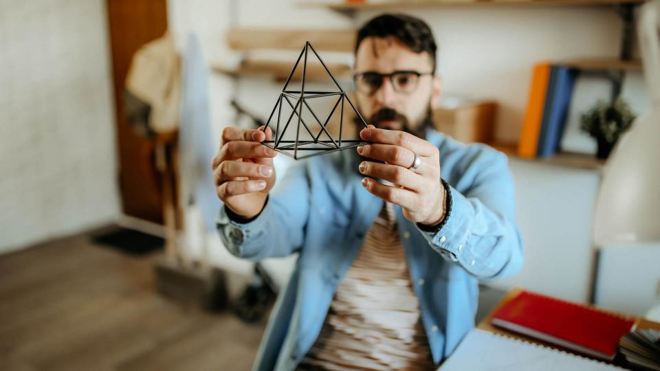 Hipster men examining pyramid for designing full product.