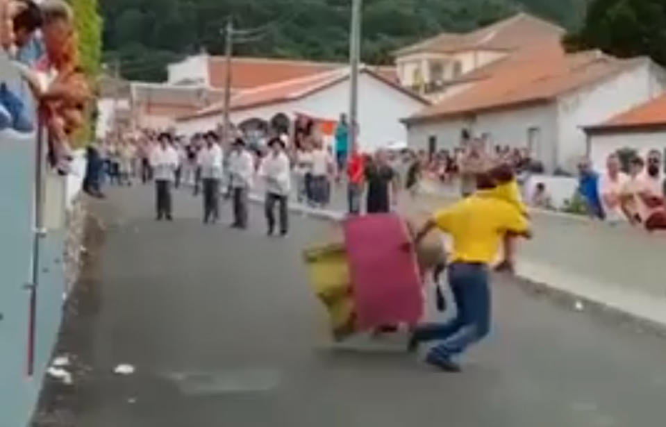 A man has been caught on video attempting to fight a bull while holding a small child in his arms. Source: Plataforma Basta de Touradas / Facebook