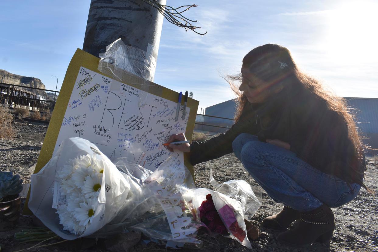 Jeannie Tuomala leaves a message on a sign, Sunday, Dec. 17, 2023, in Billings, at a memorial for four teenagers killed in a single-vehicle crash on Saturday. Police say speed, no seatbelts and possibly alcohol appear to have contributed to the accident.