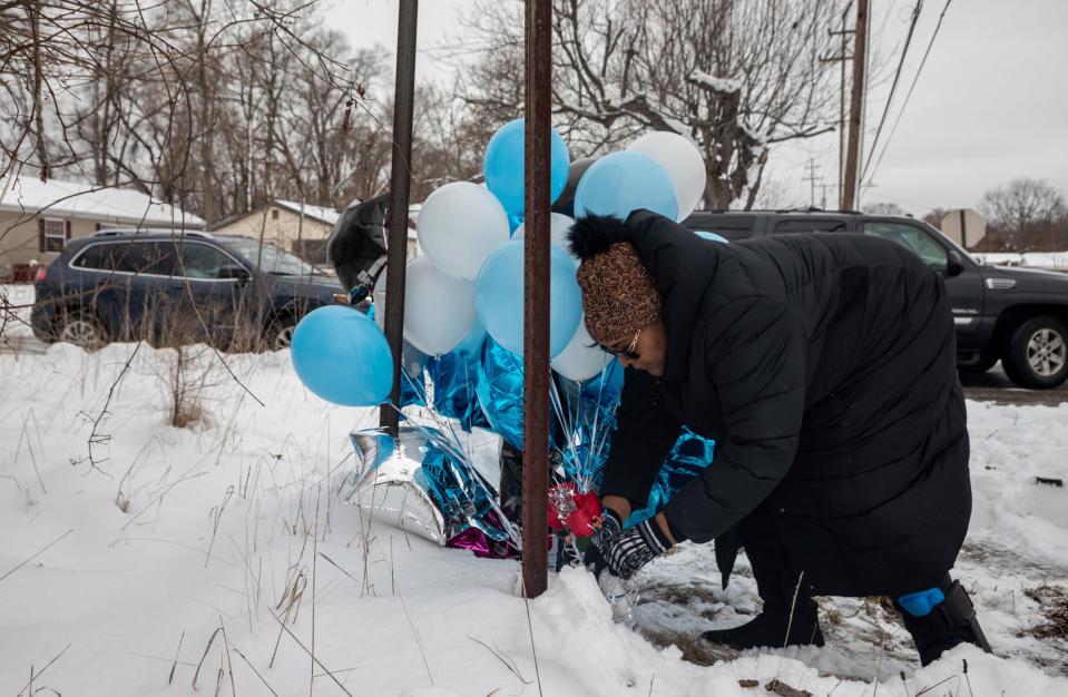 Vicki Shaw of Auburn Hills places balloons and flowers on the ice before a vigil in Pontiac on Sunday, Jan. 29, 2023. 