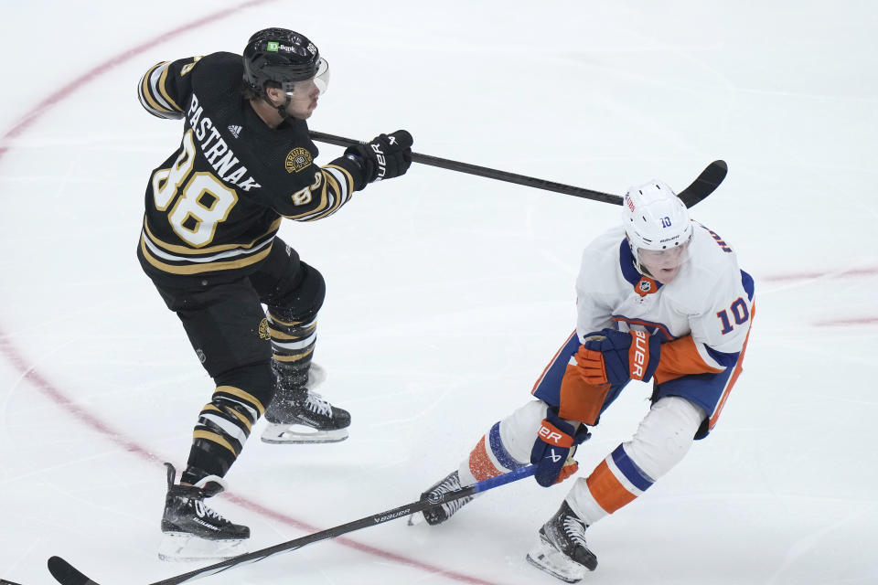 Boston Bruins right wing David Pastrnak (88) follows through on his shot on goal to score as New York Islanders right wing Simon Holmstrom (10) defends in the third period of an NHL hockey game, Thursday, Nov. 9, 2023, in Boston. (AP Photo/Steven Senne)