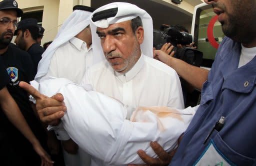 A Qatari man carries the body of his child, who died in a blaze that whipped through a shopping mall in Doha on Monday. Firefighters in Qatar told Wednesday how they tried to rescue 13 children trapped by a blaze in a mall nursery but by the time they reached the toddlers most were dead, huddled in the arms of two fellow firemen who perished during the rescue attempt