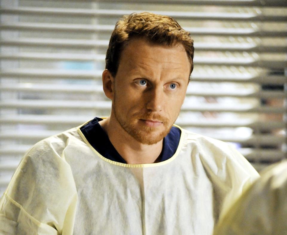 Owen Hunt from Grey's Anatomy in scrubs, looking concerned in a hospital setting