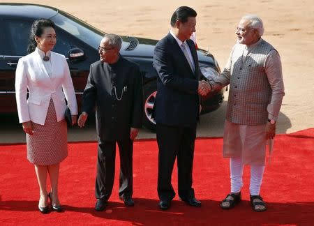 Prime Minister Narendra Modi (R) and China's President Xi Jinping (2nd R) shake hands as Xi's wife Peng Liyuan and President Pranab Mukherjee (2nd L) look on during Xi's ceremonial reception at the forecourt of Rashtrapati Bhavan presidential palace in New Delhi September 18, 2014. REUTERS/Ahmad Masood