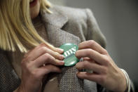 Abigail Bessler, daughter of Democratic presidential candidate Sen. Amy Klobuchar, D-Minn., puts on a button while campaigning Tuesday, Jan. 21, 2020, in Stanton, Iowa. (AP Photo/Marcio Jose Sanchez)