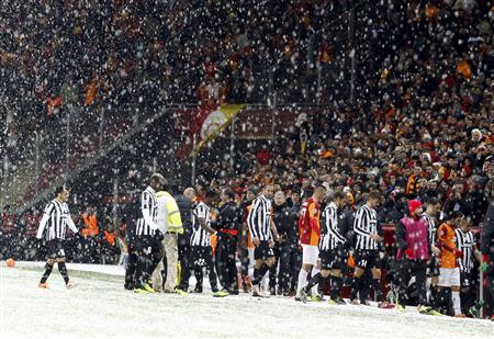 Players of Galatasaray and Juventus walk out of the pitch as their match is paused for 20 minutes due a heavy snowfall during their Champions League soccer match in Istanbul December 10, 2013. REUTERS/Osman Orsal