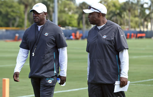 FILE - In this May 10, 2019, file photo, Miami Dolphins coach Brian Flores, left, and general manager Chris Grier walk off the field at NFL rookie camp in Davie, Fla. Flores and Grier are among the six Black coaches, general managers and high-ranking executives in the NFL. (AP Photo/Brynn Anderson, File)