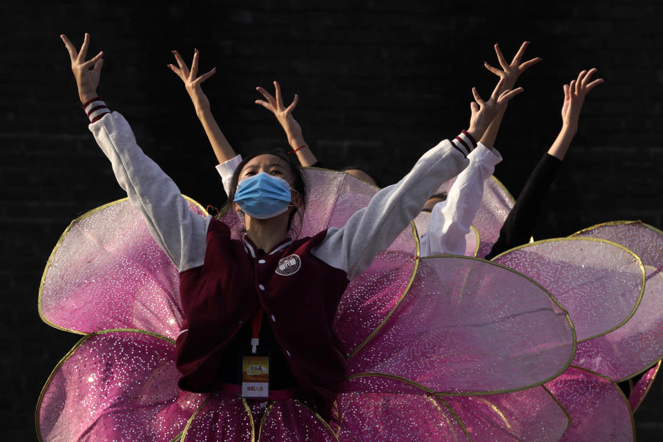 Performers wearing masks to protect from the coronavirus rehearse for a show at the Badaling Great Wall of China on the outskirts of Beijing on Tuesday, Oct. 6, 2020. Chinese tourists took 425 million domestic trips in the first half of the eight-day National Day holiday, generating $45.9 billion in tourism revenue, according to China's ministry of culture and tourism. The holiday this year, which coincides with the Mid-Autumn Festival, will be a litmus test of whether China's tourism industry can bounce back after being battered by COVID-19.(AP Photo/Ng Han Guan)