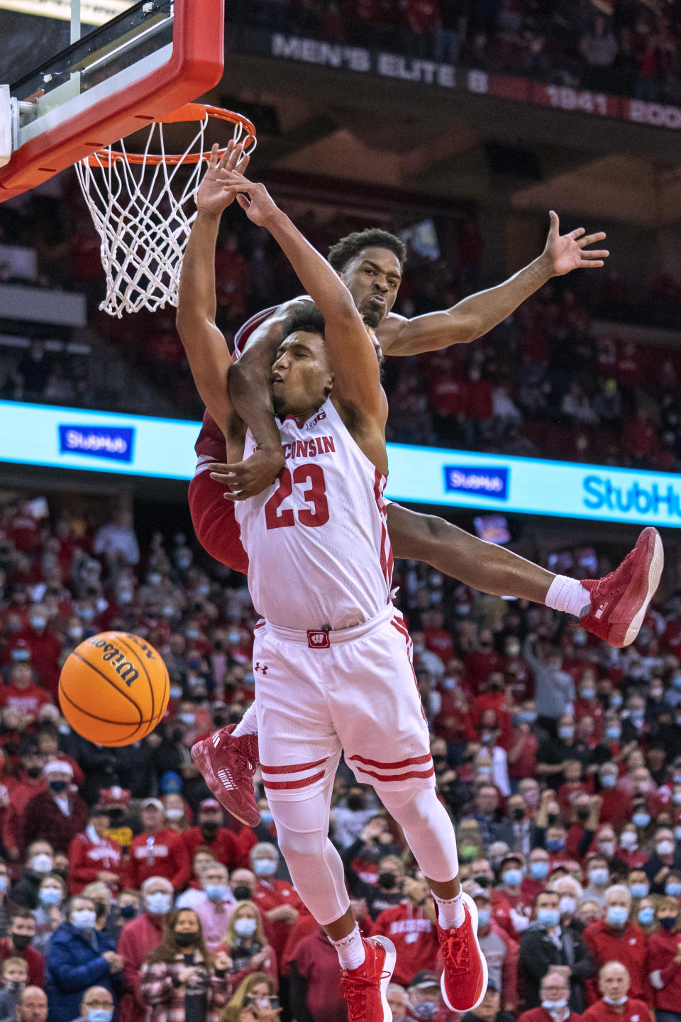 Indiana's Xavier Johnson, top, fouls Wisconsin's Chucky Hepburn (23) during the second half of an NCAA college basketball game Wednesday, Dec. 8, 2021, in Madison, Wis. Wisconsin won 64-59. (AP Photo/Andy Manis)
