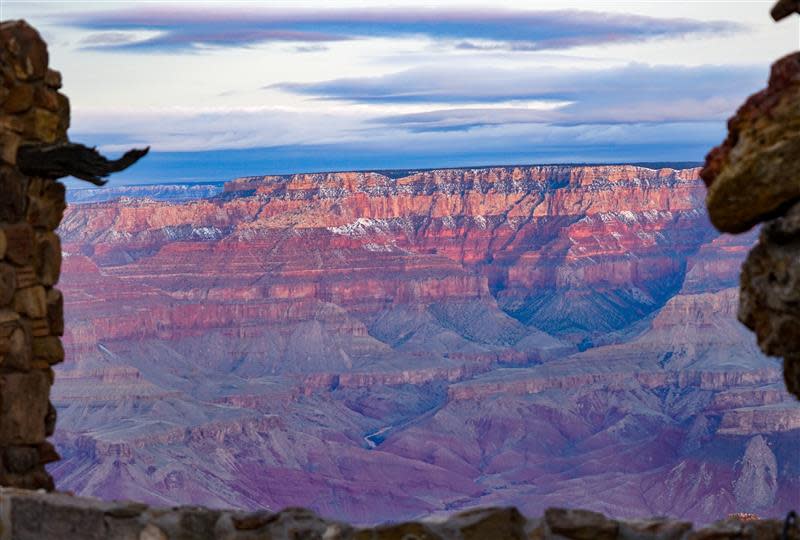 Evening colors and fresh snow on the Grand Canyon's North Rim, frame the Colorado River, which looks like a thin thread in this February 2019 file photo.