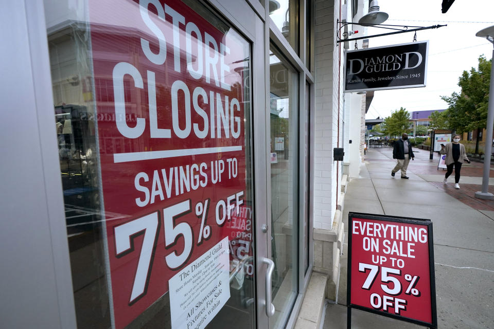 Passersby walk past a business storefront with store closing and sale signs, Wednesday, Sept. 2, 2020, in Dedham, Mass. The number of people seeking U.S. unemployment aid rose slightly to 870,000, a historically high figure that shows that the viral pandemic is still squeezing restaurants, airlines, hotels and many other businesses six months after it first erupted. (AP Photo/Steven Senne)