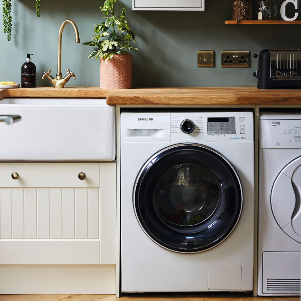 Blue painted utility room with fitted washer and dryer