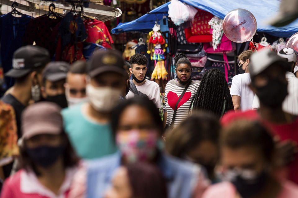 FILE - In this Dec. 23, 2020 file photo, pedestrians shop in an outdoor market area, days before a COVID-19 lockdown goes into effect in Sao Paulo, Brazil. Brazil has suffered more than 200,000 COVID-19 deaths, the second-highest total in the world after the United States, with infections and deaths surging again. (AP Photo/Carla Carniel)