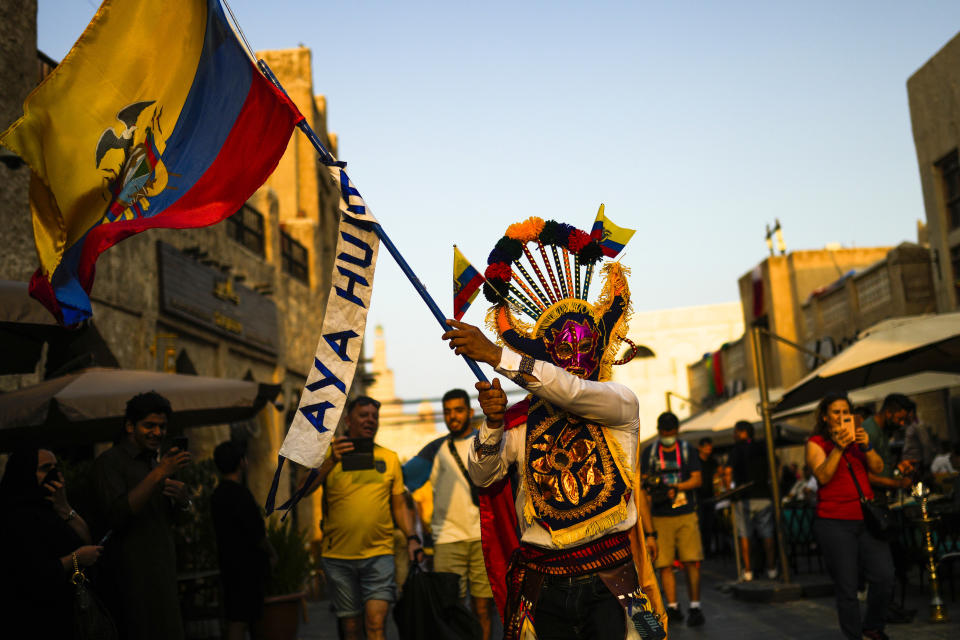 An Ecuador supporter waves an Ecuador flag as he cheers, one day ahead of the World Cup kick off, in downtown Doha, Qatar, Saturday, Nov. 19, 2022. (AP Photo/Francisco Seco)