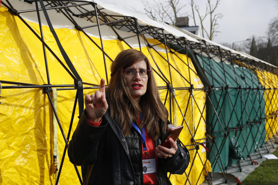 Dr Sharon Raymond makes a call to one the London Taxi cabs being used as a Vaxi Taxi during the pilot project of pop up vaccination drive 'Vaxi Taxi' in Kilburn, London, Sunday, Feb. 28, 2021. The pilot scheme, funded by the Covid Crisis Rescue Foundation, aims to help ferry supplies and patients to temporary clinics set up in faith and community centres across the capital. People don’t even need to leave the backseat if they didn’t want to in order to receive their inoculation. (AP Photo/Alastair Grant)