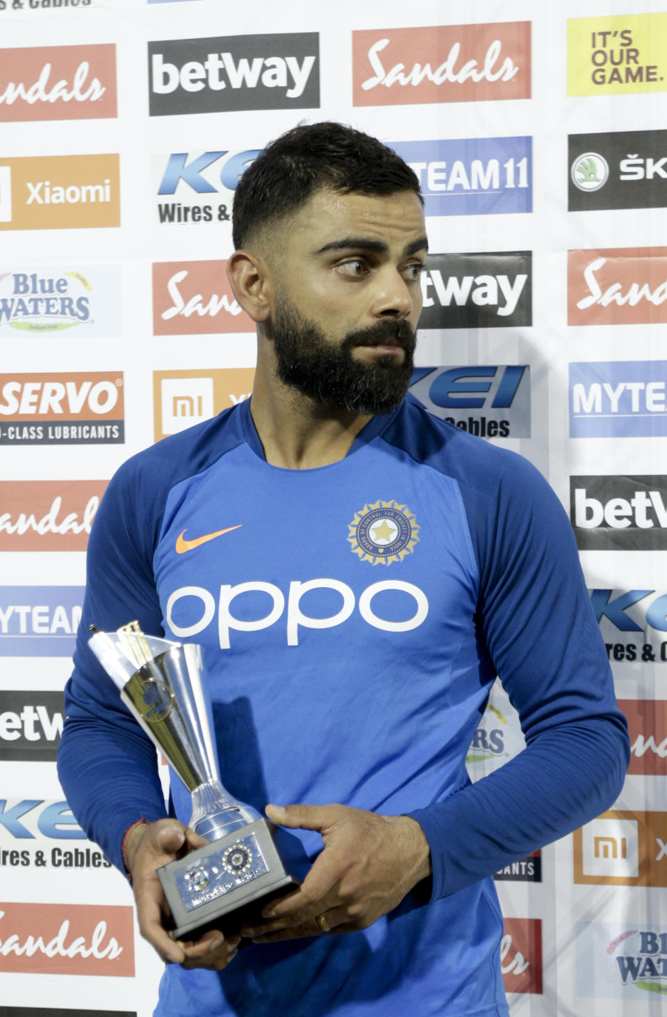 India captain Virat Kohli holds the "Man of the Match" trophy at the end of the third One-Day International cricket match against West Indies in Port of Spain, Trinidad, Wednesday, Aug. 14, 2019. India won by 6 wickets, with 15 balls remaining. (AP Photo/Arnulfo Franco)