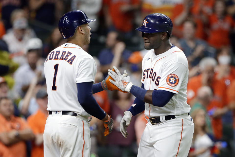 Houston Astros' Carlos Correa (1) and Yordan Alvarez, right, celebrate Alvarez's home run against the Oakland Athletics during the sixth inning of a baseball game Thursday, April 8, 2021, in Houston. (AP Photo/Michael Wyke)