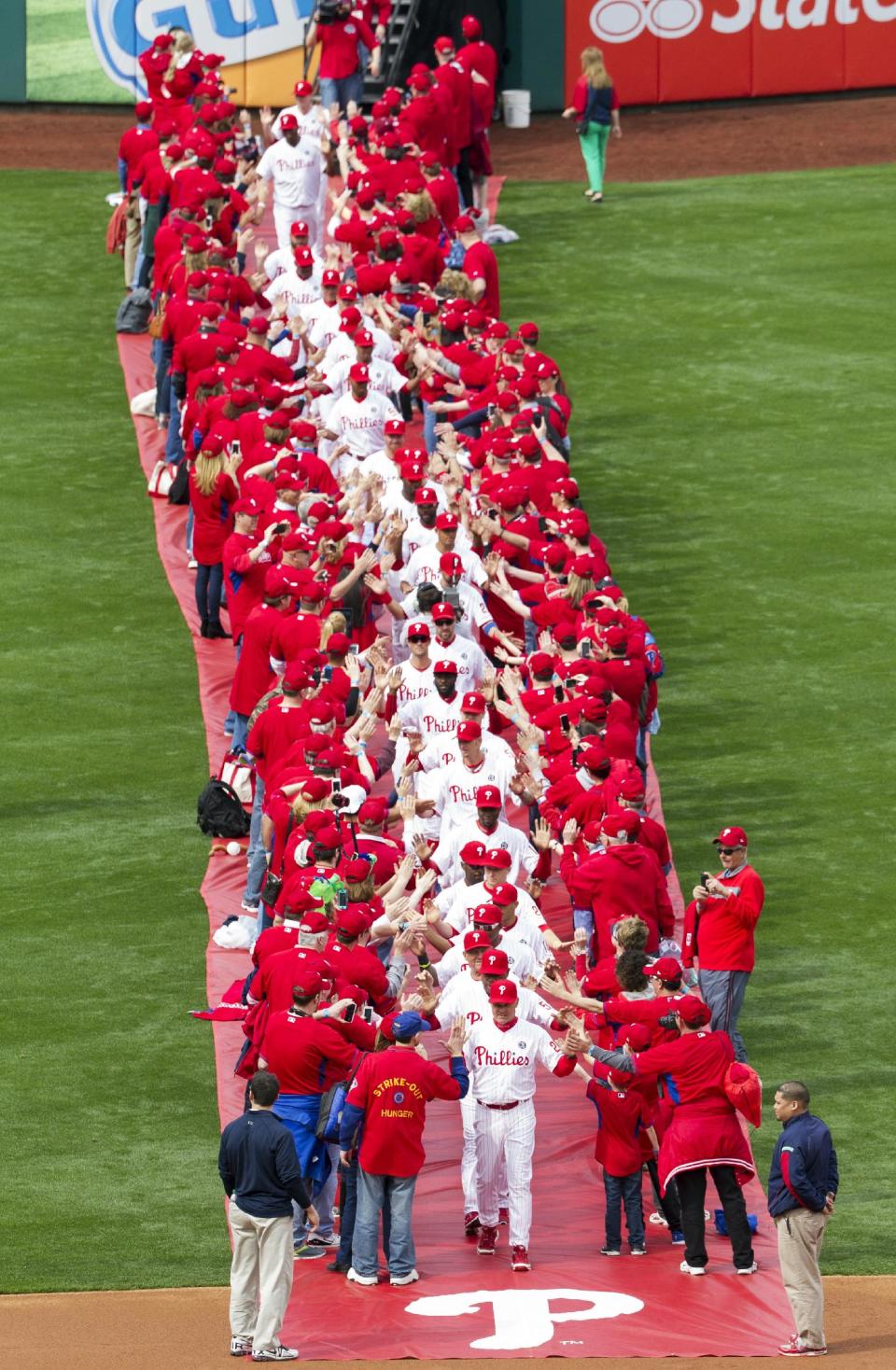 Philadelphia Phillies' manager Ryne Sandberg leads his team from centerfield while surrounded by fans for an opening day baseball game between the Milwaukee Brewers and Philadelphia Phillies in Philadelphia, Tuesday, April 8, 2014. (AP Photo/Chris Szagola)