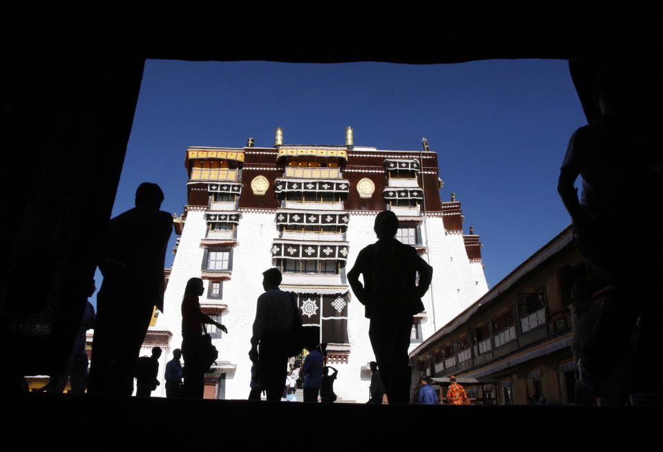 FILE - In this June 20, 2009 file photo, tourists walk through the Potala Palace, the former home of the Dalai Lama before he fled Tibet after a failed Tibetan uprising against Chinese rule in 1959, in Lhasa, the capital of Tibet, China. Tibet is seeing a boom in Chinese visitors, meaning that the government's latest ban on foreigners following self-immolation protests against Beijing's rule has barely dented the region's tourism industry. (AP Photo/Greg Baker, File)