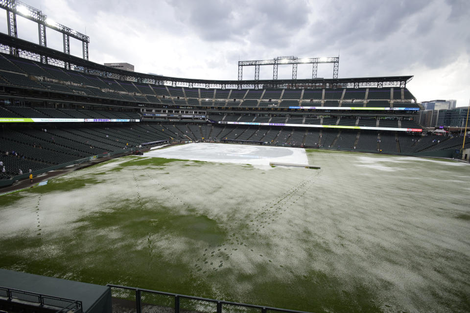 A mixture of water and hail covers the outfield after a summer storm Thursday, June 29, 2023, in Denver. The Colorado Rockies were scheduled to play against the Los Angeles Dodgers. (AP Photo/David Zalubowski)