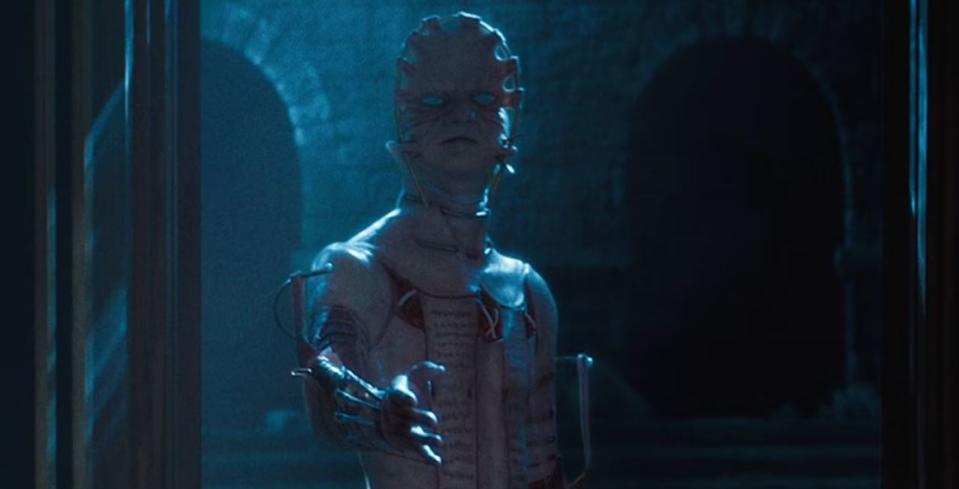 An image from Hellraiser 2022 shows The Masque a cenobite whose face is stretched across a metal plate