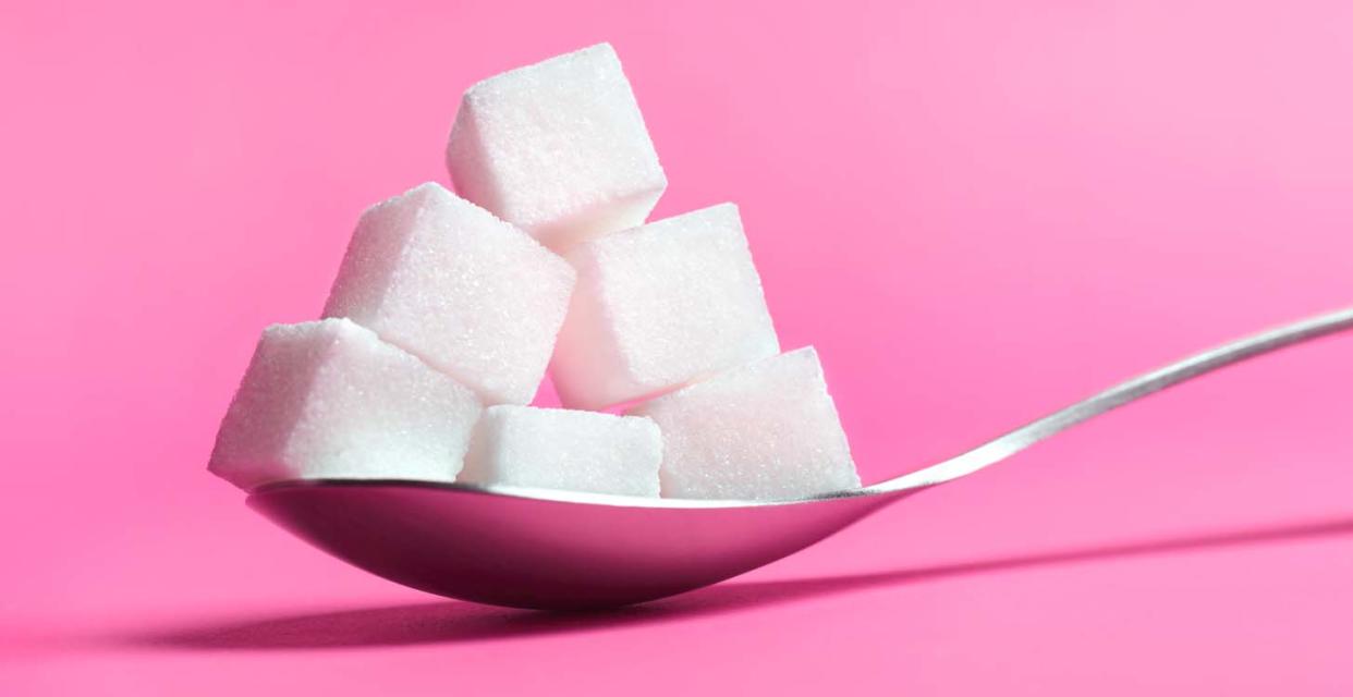 Sugar cubes stacked on a spoon. 