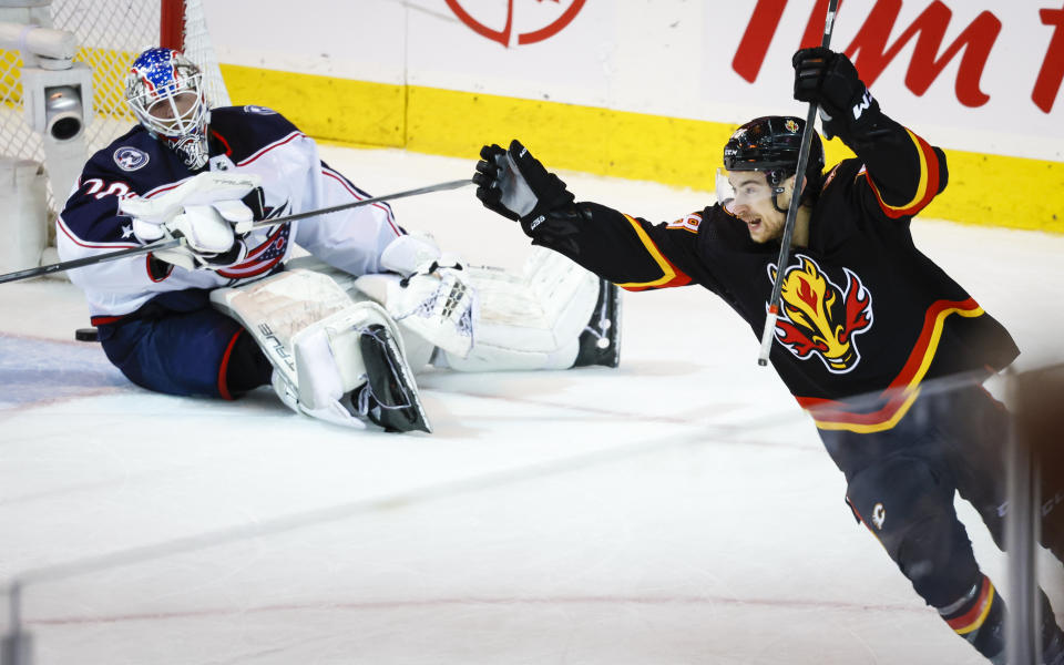 Columbus Blue Jackets goalie Joonas Korpisalo, left, looks on as Calgary Flames forward Andrew Mangiapane celebrates his team's win in overtime of an NHL hockey game in Calgary, Alberta, Monday, Jan. 23, 2023. (Jeff McIntosh/The Canadian Press via AP)