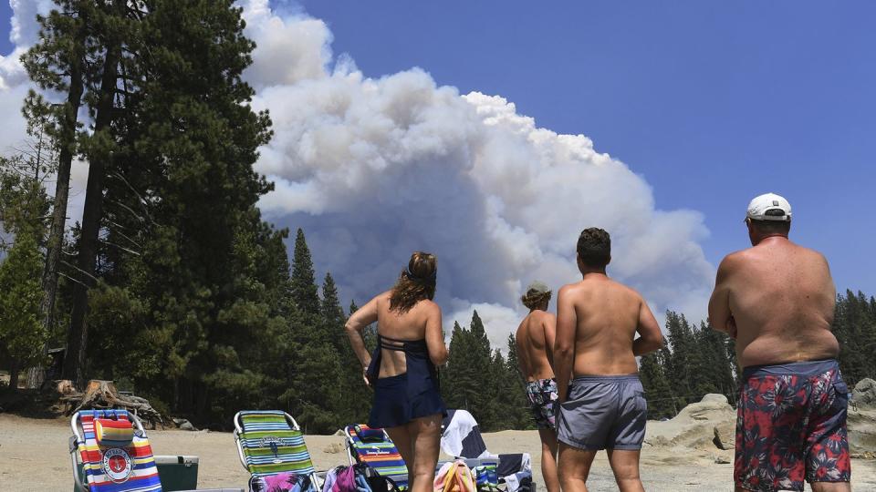 Eine Familie beobachtet vom Ufer des Shaver Lake aus den aufsteigenden Rauch eines Waldbrandes. Drei Wochen nach dem Ausbruch zahlreicher Waldbrände in Kalifornien kämpft die Feuerwehr dort weiter gegen die Flammen.