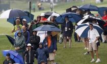 Golf fans wait along a fairway for play to resume during a rain delay at the start of the second round of the PGA Championship at Valhalla Golf Club in Louisville, Kentucky, August 8, 2014. REUTERS/John Sommers II