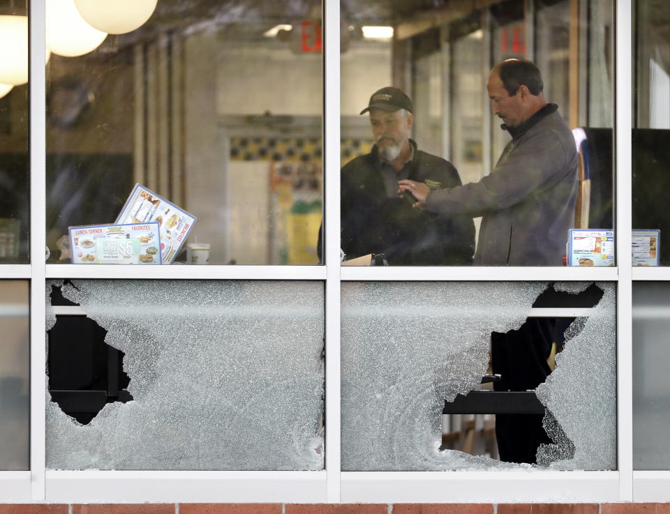 <p>People look over an area near a window shot out at a Waffle House restaurant Sunday, April 22, 2018, in Nashville, Tenn. Several people died after a gunman opened fire at the restaurant early Sunday. (Photo: Mark Humphrey/AP) </p>