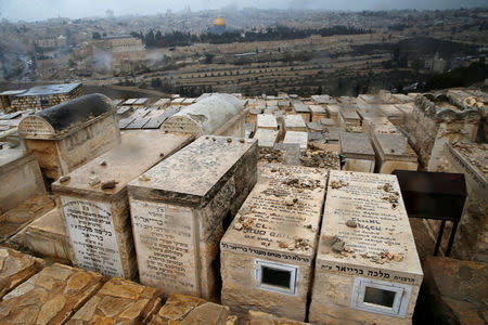 A Jewish cemetery on the Mount of Olives is seen in the foreground as the Dome of the Rock, located in Jerusalem's Old City on the compound known to Muslims as Noble Sanctuary and to Jews as Temple Mount, is seen in the background, December 6, 2017. REUTERS/Ammar Awad