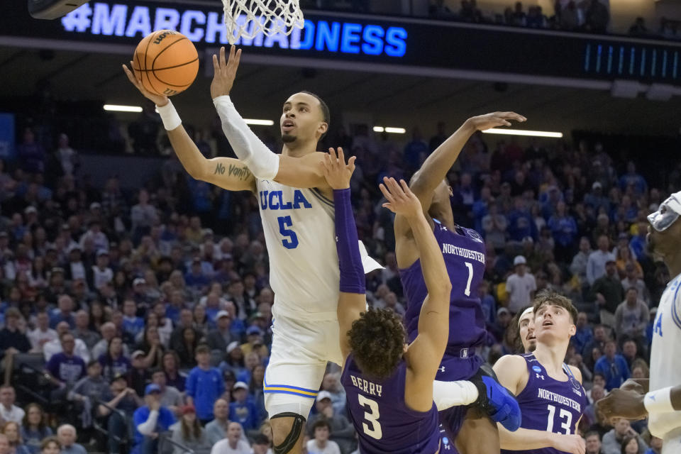 UCLA guard Amari Bailey (5) lays the ball up next to Northwestern guard Ty Berry (3) and guard Chase Audige (1) during the second half of a second-round college basketball game in the men's NCAA Tournament in Sacramento, Calif., Saturday, March 18, 2023. UCLA won 68-63. (AP Photo/Randall Benton)