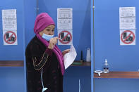 A woman walks to cast her ballot at a polling station during the presidential election in Tashkent, Uzbekistan, Sunday, Oct. 24, 2021. Uzbekistan's President, Shavkat Mirziyoyev, who has relaxed many of the policies of his dictatorial predecessor but has made little effort at political reform, is expected to win a new term by a landslide against weak competition in an election Sunday. (AP Photo)