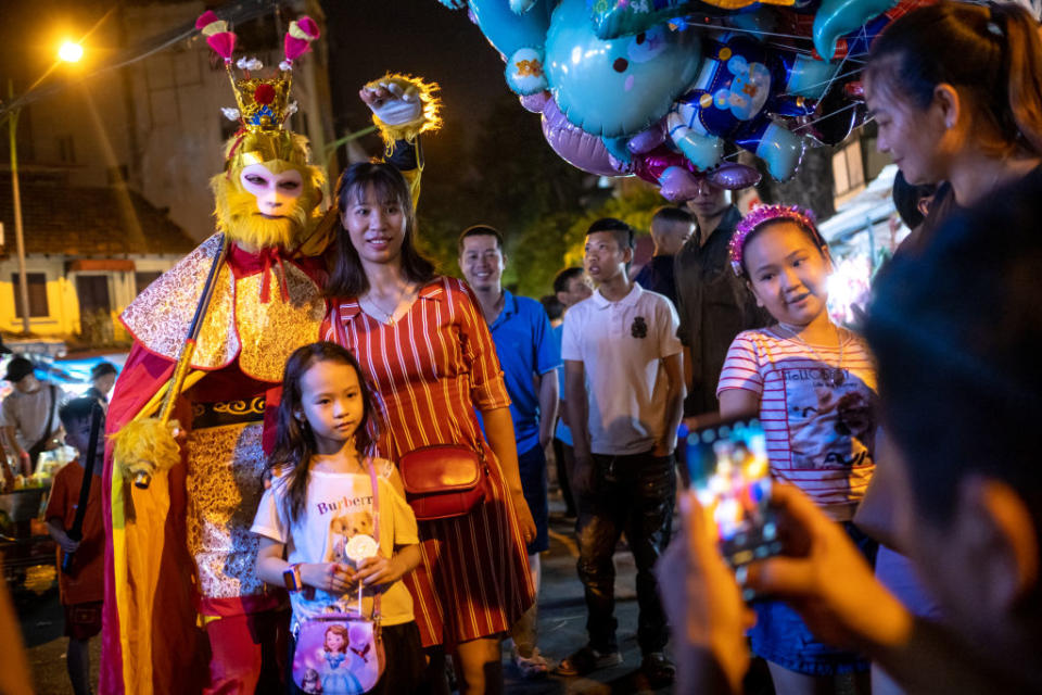 Visitors pose for photos with the costumed Monkey King from Chinese mythology on Sept. 26, 2020 in Hanoi, Vietnam. The Mid-Autumn Festival is an occasion for a children's night out and family gathering<span class="copyright">Linh Pham/Getty Images</span>