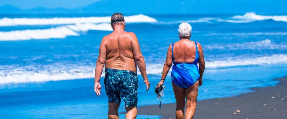 Older people walking along the beach. Costa Rica, tourist paradise