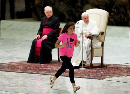 Pope Francis allows a little girl suffering from an undisclosed illness to move around undisturbed clapping and dancing on the stage for most of his general audience in Paul VI Hall at the Vatican