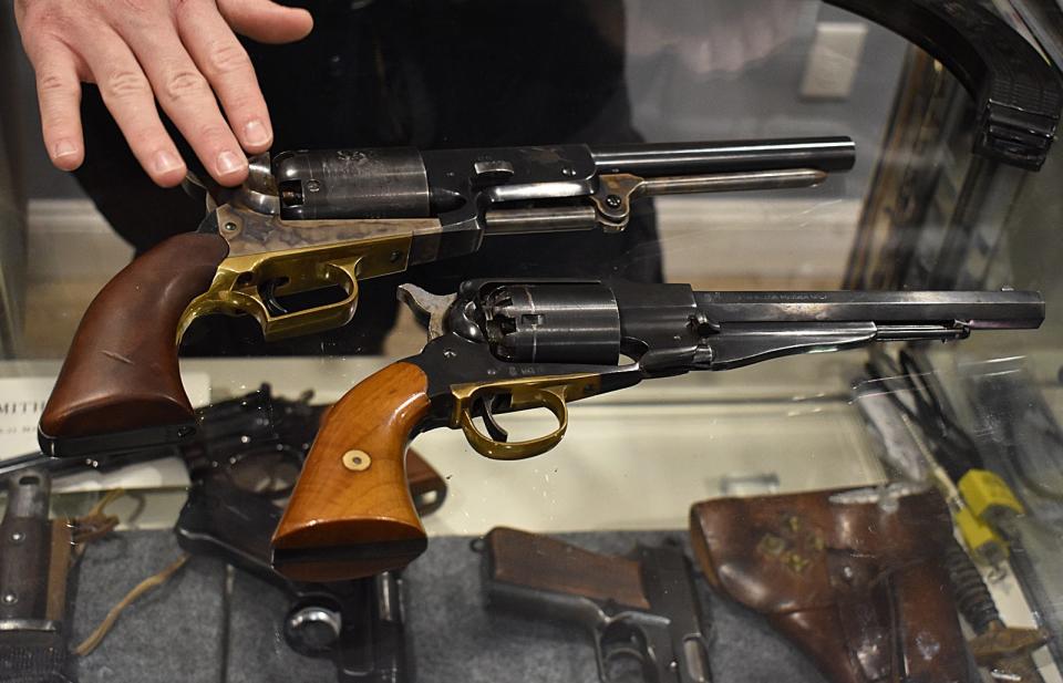 Michael O'Reagan shows a Colt Walker Dragoon and an 1860 Remington reproduction at Collectable Firearms & Militaria on Rhode Island Avenue in Fall River.