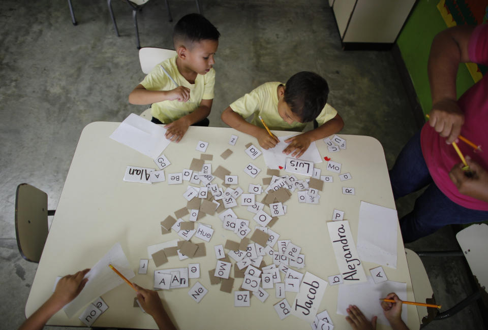 In this Oct. 7, 2019 photo, children work during class at a school in Caracas, Venezuela. Thousands of Venezuelan teachers vented their frustration, staging a two-day strike this week across the crisis torn nation. They demanded better working conditions, which included fair wages and urgent attention to unmaintained schools falling into ruins. (AP Photo/Ariana Cubillos)