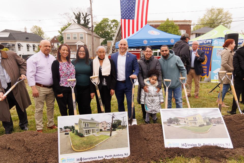 Perth Amboy Mayor Helmin J. Caba, center, joins the families who will receive homes as part of a Morris Habitat for Humanity program.