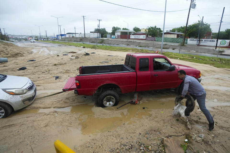 A driver tries to unblock his car from the mud at a avenue flooded by the rains of Hurricane Norma in San Jose del Cabo, Mexico, Saturday, Oct. 21, 2023. Norma had weakened and was downgraded to Category 1 on the hurricane wind scale. It was located 25 miles west of Cabo San Lucas storm with winds of 85 mph (140 kmh) and expected to make landfall on Saturday, according to the U.S. (AP Photo/Fernando Llano)
