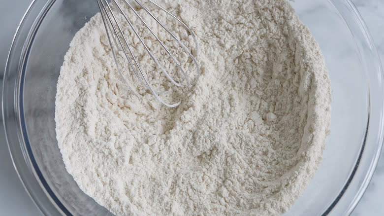 flour in glass bowl  with whisk