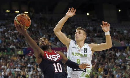 Kyrie Irving of the U.S. (L) goes up for a basket past Slovenia's Edo Muric during their Basketball World Cup quarter-final game in Barcelona September 9, 2014. REUTERS/Albert Gea