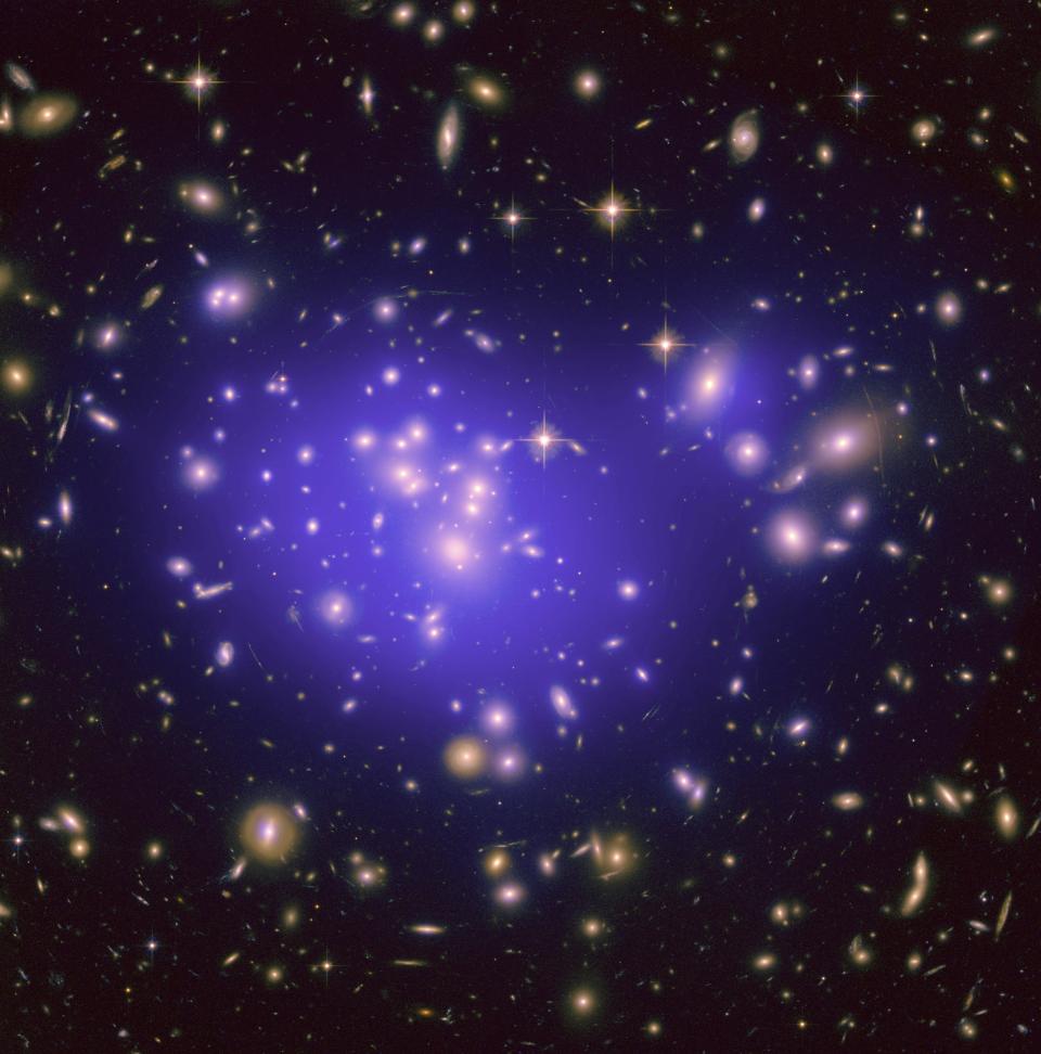 an image containing lots of galaxies, there is a hazy purple glow surrounding those in the center of the image, this halo represents dark matter.