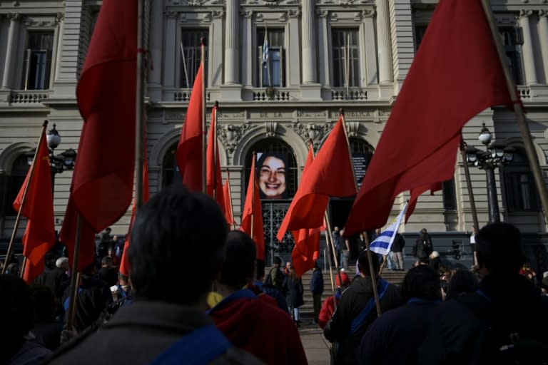 Miembros del Partido Comunista de Uruguay sostienen banderas durante un homenaje a Amelia Sanjurjo, militante comunista cuyos restos fueron hallados en un predio militar en 2023, antes de su funeral en Montevideo el 6 de junio de 2024. (Eitan ABRAMOVICH)