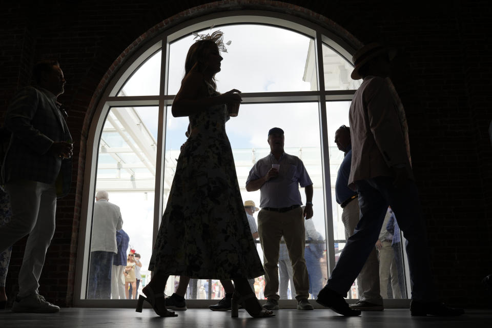 Race fans walk though the grounds of Churchill Downs before the 150th running of the Kentucky Derby horse race Saturday, May 4, 2024, in Louisville, Ky. (AP Photo/Charlie Riedel)