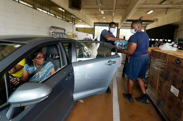 PHOTO: Recruits for the Fire Department place cases of bottled water in a resident's car as part of the city's response to longstanding water system problems in Jackson, Miss., Aug. 18, 2022. (Rogelio V. Solis/AP)